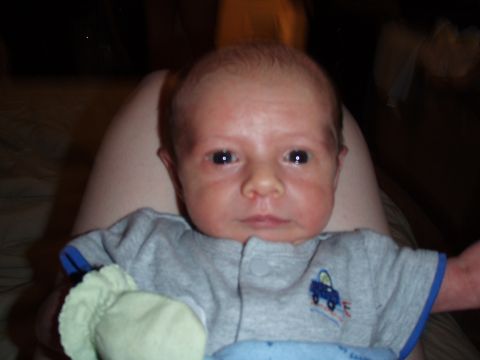 1997 Ford F-250 - A baby is held, wearing a gray onesie with a small blue car graphic on the chest.