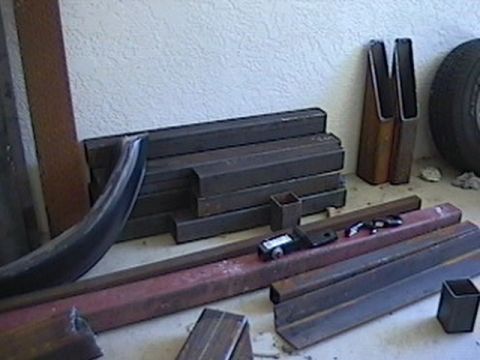 1992 Ford Bronco - Various metal parts, including tubing and a curved section, are laid out on the ground.