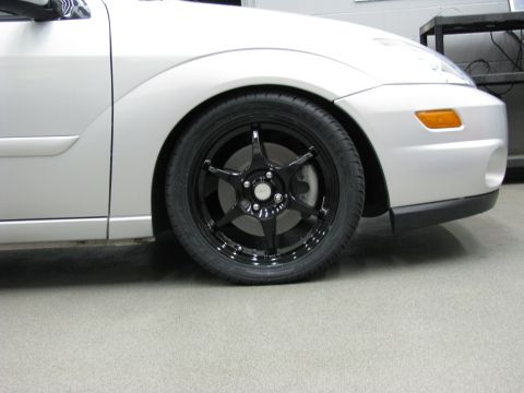 2003 Ford Focus - Close-up of the front wheel and fender of a 2003 Ford Focus with aftermarket rims.