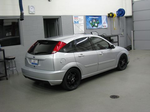 2003 Ford Focus - Silver 2003 Ford Focus hatchback with black rims parked in a garage.