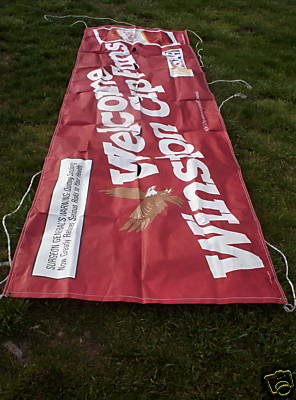 1993 Ford C-350 (Centurion Conversions) - A large red banner with white lettering and an eagle graphic is spread out on a grassy surface.