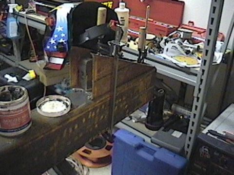 1992 Ford Bronco - A cluttered workbench holds various tools and supplies, including a welding mask with a patriotic design.