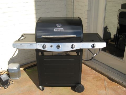 2006 Ford F-150 - A black gas grill with side shelves and three control knobs sits on a patio.