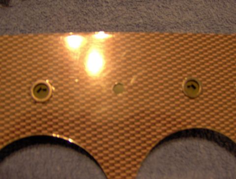 1978 Ford Bronco - Close-up of a vehicle's dashboard gauge cluster panel, showing a carbon fiber texture and mounting points.