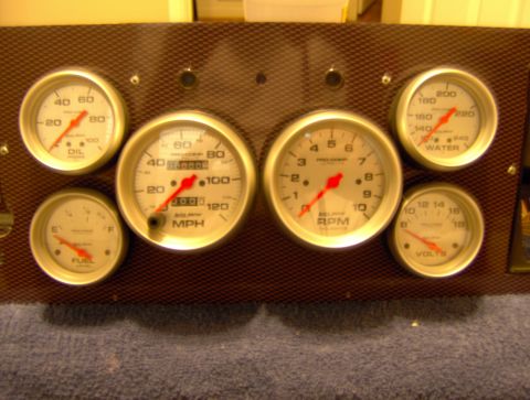 1978 Ford Bronco - A set of aftermarket dashboard gauges are mounted on a textured panel.