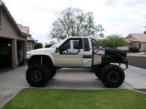 1986 Toyota Hilux - Modified 1986 Toyota Hilux pickup truck with custom roll cage and off-road tires.