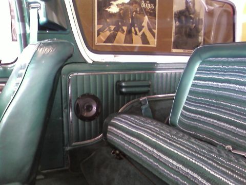 1978 Ford Bronco - The interior of a 1978 Ford Bronco shows striped seats and a Beatles poster on the window.