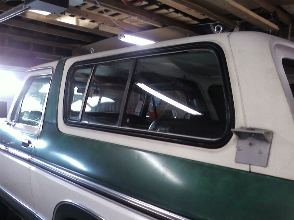 1978 Ford Bronco side view, green and white paint, in a garage
