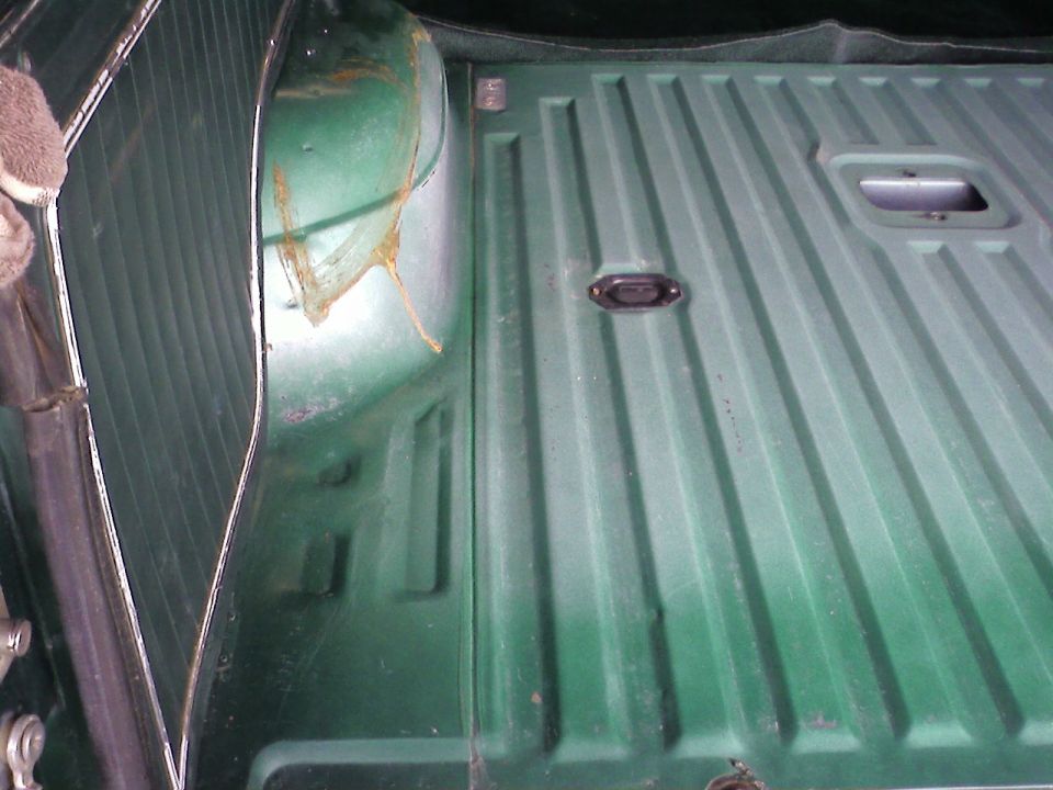 green truck bed with ribbed floor and tie-down points