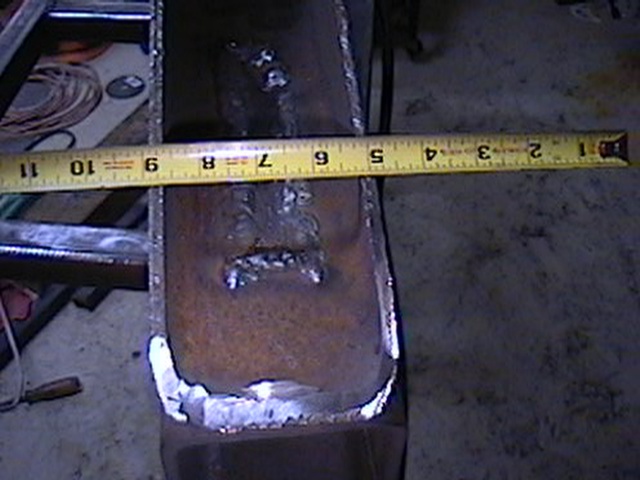 Welded metal part measured with tape measure