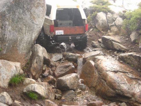 1989 Ford Bronco - This SUV is carefully maneuvering through a challenging rocky obstacle on an off-road trail.