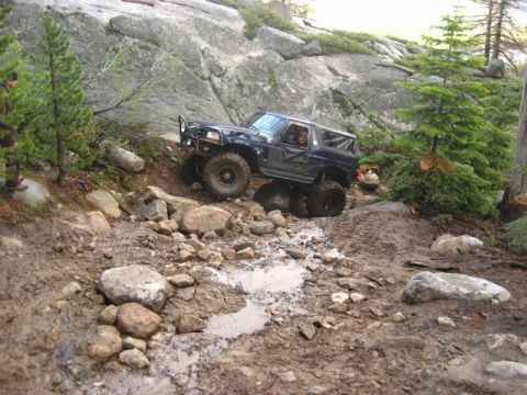 1989 Ford Bronco - This lifted SUV navigates a challenging rocky and muddy off-road trail, its off-road capabilities.
