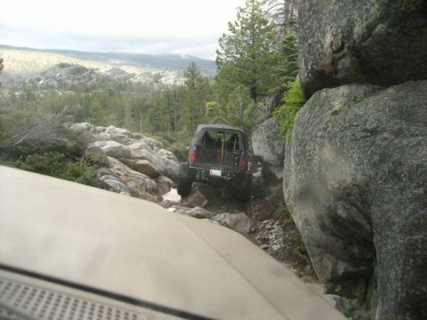 1989 Ford Bronco - A black 1989 Ford Bronco navigates a challenging rocky terrain, its off-road capabilities.