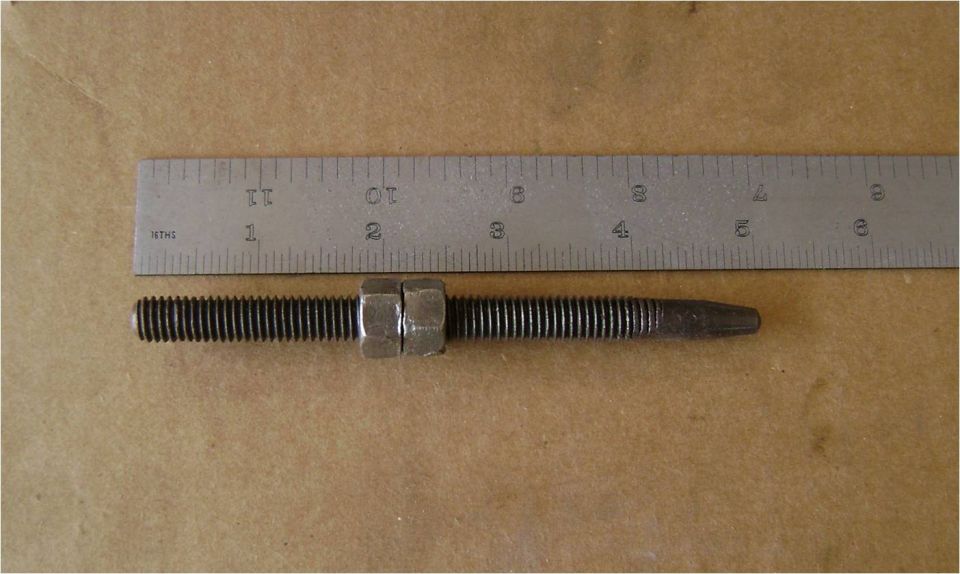 Threaded stud or bolt with a nut measured against a ruler