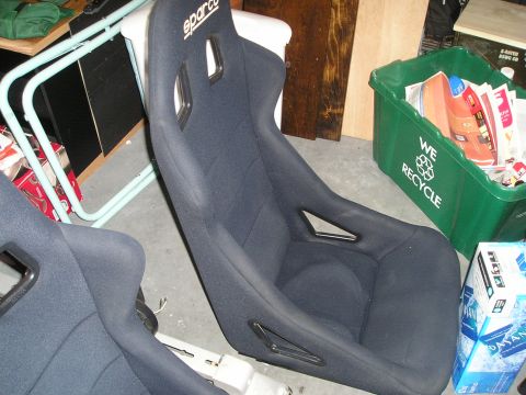 1996 Ford Bronco - Pair of Sparco racing seats in a garage setting, with a recycling bin visible in the background.
