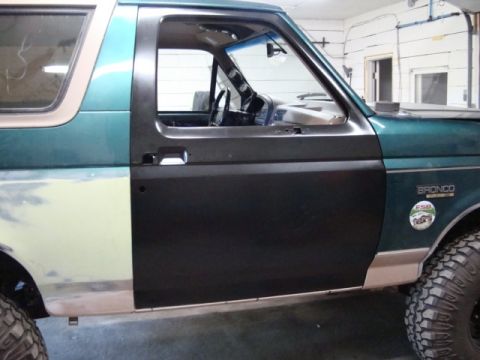 1996 Ford Bronco - Photograph of a teal Ford Bronco's side with a freshly painted door, not a technical document.