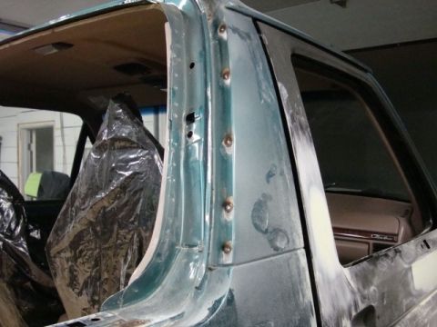 1996 Ford Bronco - Photograph of a vehicle pillar in primer with the interior masked during paint prep, not a technical document.