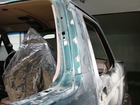 1996 Ford Bronco - Photograph of a vehicle rear pillar in primer with the interior masked, not a technical document.