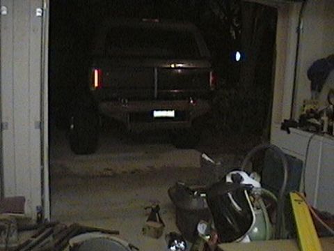 1992 Ford Bronco - The rear of a 1992 Ford Bronco is visible in a garage, with its taillights lit.