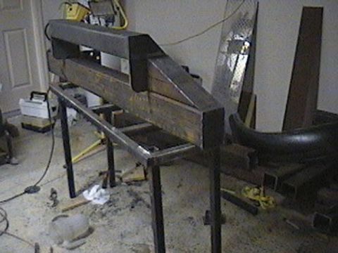 1992 Ford Bronco - Metal fabrication equipment is set up in a workshop, with a curved bumper part visible.