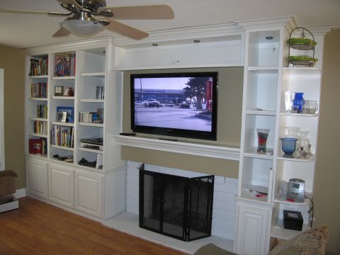 1986 Ford Bronco - A built-in entertainment center with a television above a fireplace is shown in a living room.