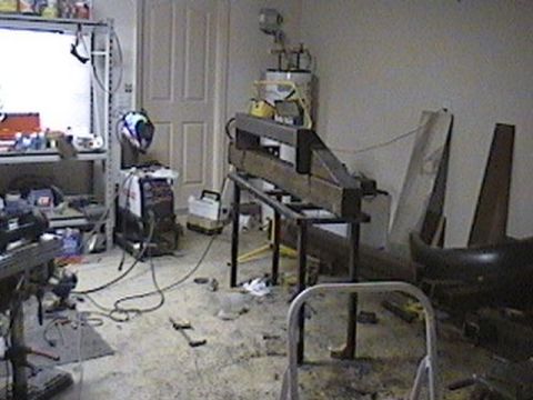 1992 Ford Bronco - A workshop environment is depicted, filled with metal fabrication equipment and tools, suggesting ongoing construction or repair work.