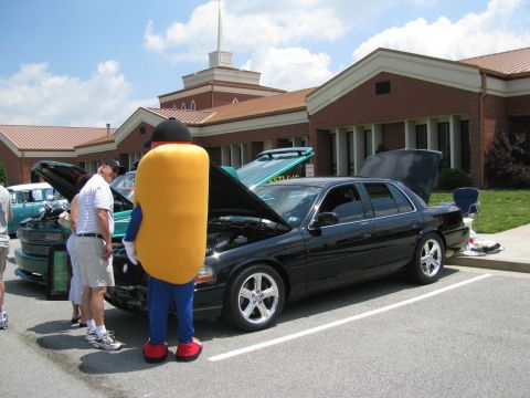 2003 Mercury Marauder - A black 2003 Mercury Marauder is displayed with its hood open, accompanied by a person in a hot dog costume at a car show.