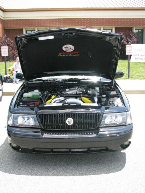 2003 Mercury Marauder - Front view of a black 2003 Mercury Marauder with its hood open, revealing the engine and 'Supercharged' badging on the underside of the hoo…