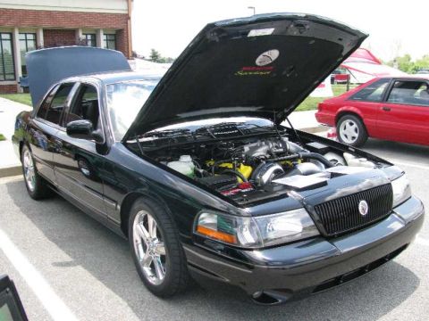 2003 Mercury Marauder - A black 2003 Mercury Marauder is parked with its hood open, revealing its engine and a yellow supercharger.