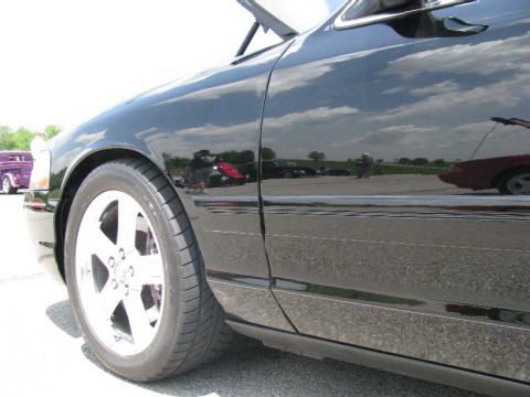 2003 Mercury Marauder - A black 2003 Mercury Marauder is seen from the side, reflecting the sky and other vehicles.