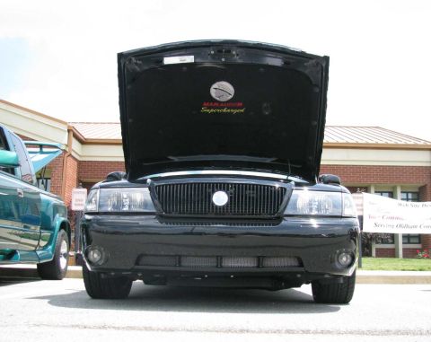 2003 Mercury Marauder - A black 2003 Mercury Marauder is parked with its hood open, displaying a "Supercharged" emblem.