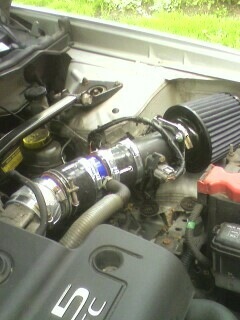 2002 Nissan SE-R - Close-up of an engine bay showing an aftermarket cold air intake system installed.