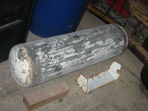 1989 Ford F-250 - An on-board air tank, likely removed from a vehicle, lies on a concrete floor with surrounding debris.