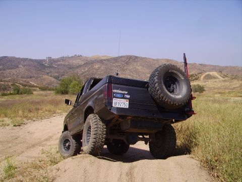 1990 Ford Bronco - This lifted Ford Bronco II is shown off-road with a spare tire mounted externally on the rear.