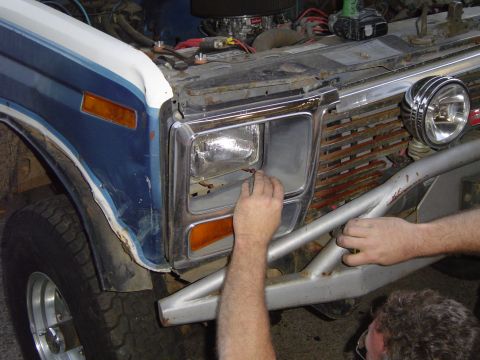 1979 Ford Bronco - A close-up of the front of a blue and white Ford Bronco, showing its grille and headlight assembly.