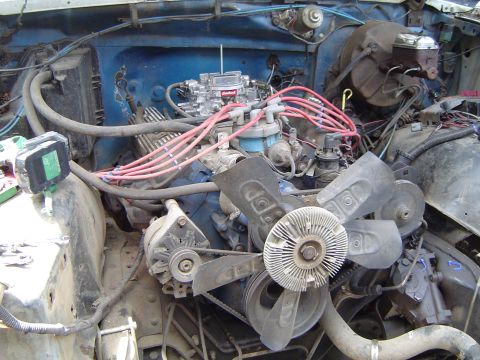 1979 Ford Bronco - Close-up view of a vehicle's engine bay, showing the carburetor, distributor, and fan assembly.