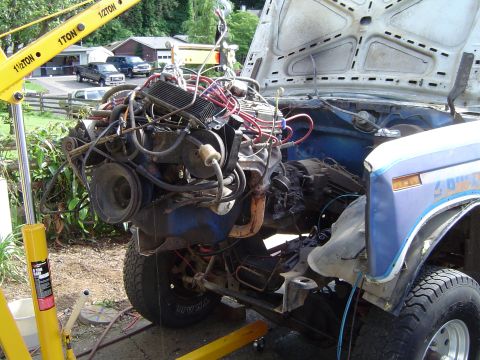 1979 Ford Bronco - Engine removal in progress with a hoist; background shows other vehicles.