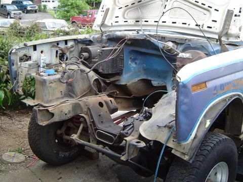 1979 Ford Bronco - Front end of a 1979 Ford Bronco with hood open, showing the disassembled engine bay and suspension.