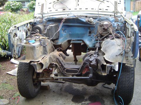 1979 Ford Bronco - The front end of a vehicle is dismantled, revealing the engine bay and suspension components.