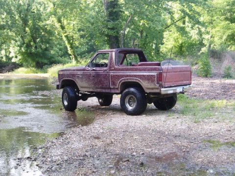 1980 Ford Bronco - This lifted 1980 Ford Bronco navigates a shallow stream, its off-road capabilities.