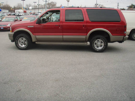 Red 2003 Ford Excursion SUV with tan lower body trim, parked on asphalt