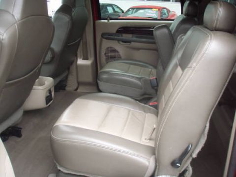 2003 Ford Excursion - The interior of a large SUV shows two-tone leather seats and a center console with cup holders.
