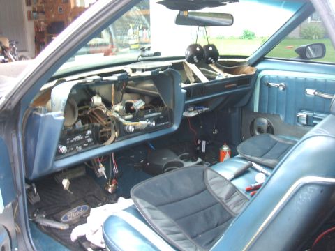 1974 Ford Ranchero - The interior of a vehicle is shown with the dashboard disassembled, revealing wiring and components.