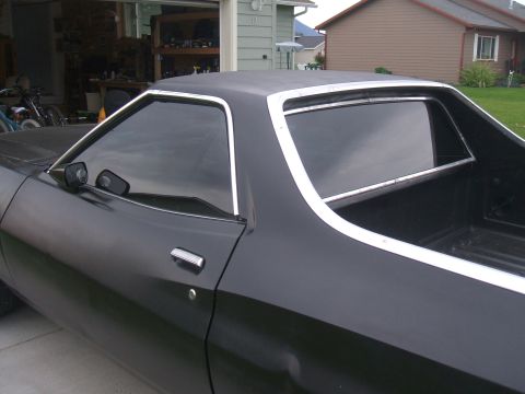 1974 Ford Ranchero - Side profile of a 1974 Ford Ranchero with black paint and chrome window trim.