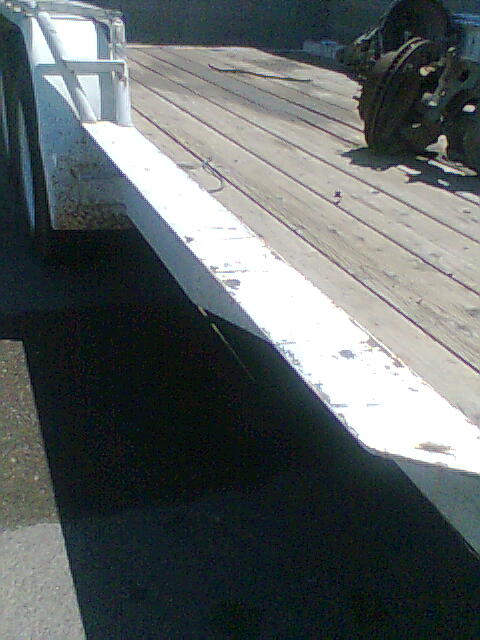 1978 Jeep Cherokee - Two axles are visible on the wooden deck of a trailer.