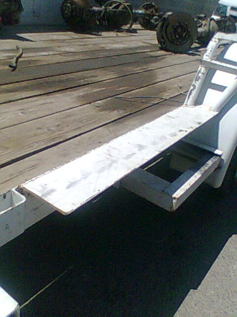 1978 Jeep Cherokee - Trailer frame and deck with various axles in the background.