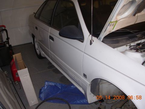 1995 Ford Taurus - This 1995 Ford Taurus sedan is shown in a garage with its hood open.