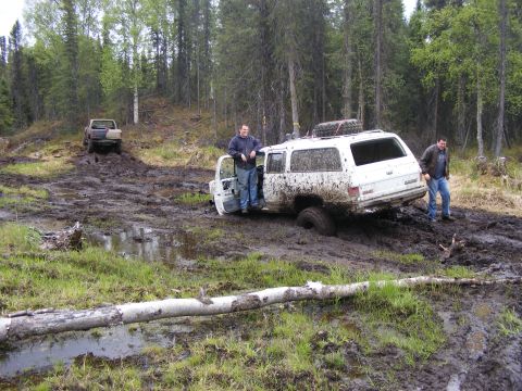 1981 Jeep CJ7 - Two men and their GMC SUV are stuck in the mud after an off-road excursion.