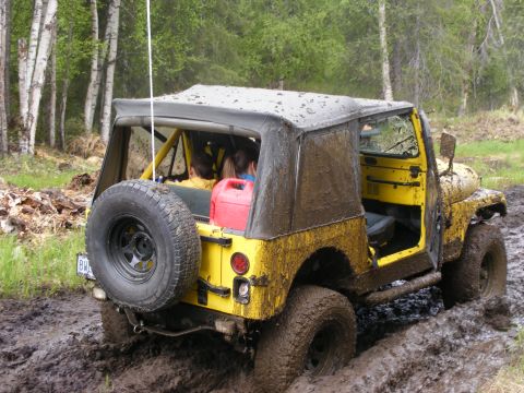 1981 Jeep CJ7 - This 1981 Jeep CJ7 is deep in the mud, showing its rear end and spare tire.
