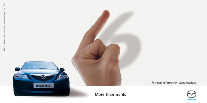 Mazda 6 advertisement with a hand casting a shadow shaped like a 6 next to the car's front end